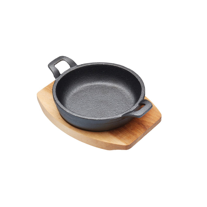 small cast iron gratin dish with wooden serving board