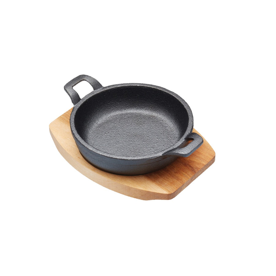 small cast iron gratin dish with wooden serving board