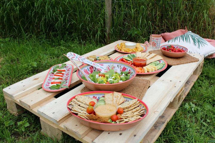 picnic food on a pallet in a field served in melamine dinnerware