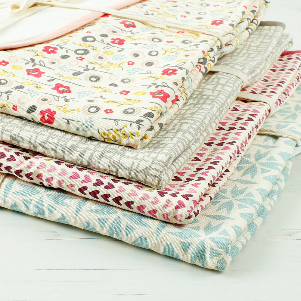 Variety of folded baby blankets in different colours and prints. Close up showing quality of fabric