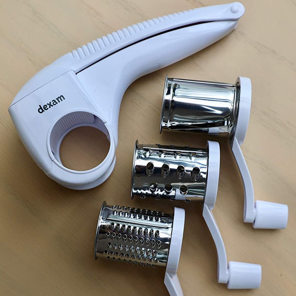 rotary grater with three changeable grating drums on wooden tabletop