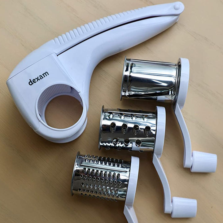 rotary grater with three changeable grating drums on wooden tabletop